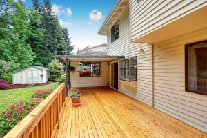 A wood deck on a home with beige siding.