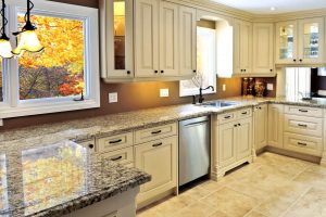 A modern kitchen with white cabinets and granite contertops