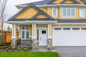 Suburban home painted yellow with dark gray trim